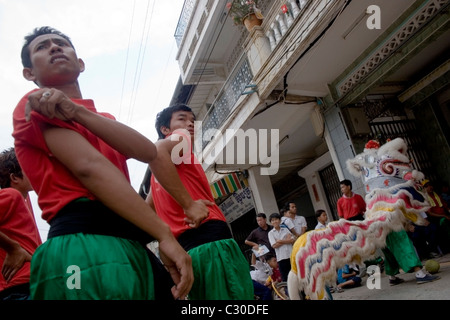 Les hommes asiatiques sont des cigarettes portant des t-shirts tout en célébrant le Nouvel An chinois sur une rue de ville au Cambodge. Banque D'Images