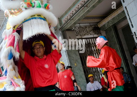 Un homme asiatique porte un costume dragon coloré tout en célébrant le Nouvel An chinois au Cambodge. Banque D'Images