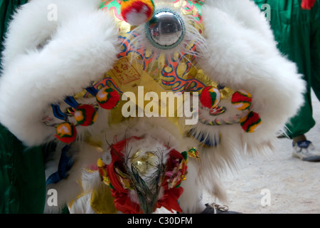 Un homme asiatique porte un costume dragon coloré tout en célébrant le Nouvel An chinois au Cambodge. Banque D'Images