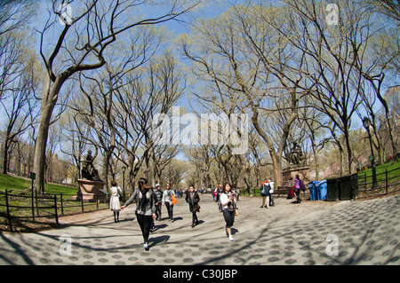 Les visiteurs bénéficient d'une journée de printemps chaud sur la promenade à pied en littéraire de Central Park à New York Banque D'Images