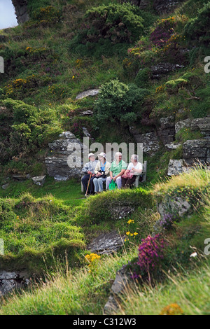 Un groupe de personnes âgées touristes se reposant sur un banc sur la côte sud-ouest près du chemin de la Vallée des roches dans le Nord du Devon England UK Banque D'Images