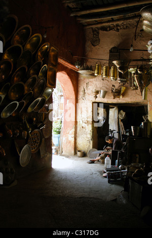 Ce jeune homme se trouve à l'extérieur des puits en laiton son magasin à un allié du côté cours dans le centre de Marrakech Banque D'Images