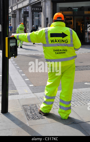 Les hommes portant des vêtements haute visibilité dans Regent Street West End Londres Angleterre Royaume-uni en réponse à interdiction des cartes Sandwich voir Alamy info le bord Banque D'Images