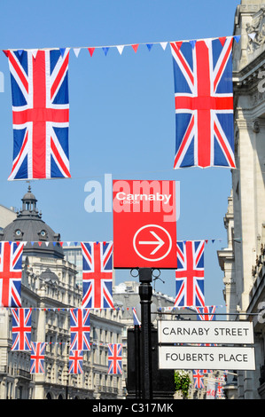 Carnaby Street signe avec l'Union Jack drapeaux et banderoles à travers et au-dessus de la rue Regent West End London England UK Banque D'Images