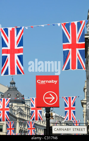 Les acheteurs de Carnaby Street sign in London West End et l'Union Jack drapeaux bleu ciel 24 Regent Street West End London England UK Banque D'Images