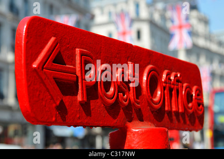 Gros plan du bureau de poste rouge, flèche pointant vers le panneau de direction sur le dessus du montant, drapeau Union Jack, au-dessus de Regent Street West End London England Banque D'Images