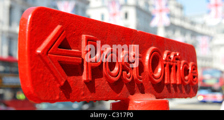 Gros plan du bureau de poste rouge, flèche pointant vers le panneau de direction sur le dessus du montant, drapeau Union Jack, au-dessus de Regent Street West End London England Banque D'Images