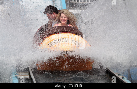 Un jeune couple refroidir complètement sur un journal de trajet sur la jetée de Brighton. Photo par James Boardman. Banque D'Images