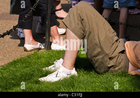 Un jeune homme (pas identifiables) se trouve la détente au soleil sur l'herbe Banque D'Images