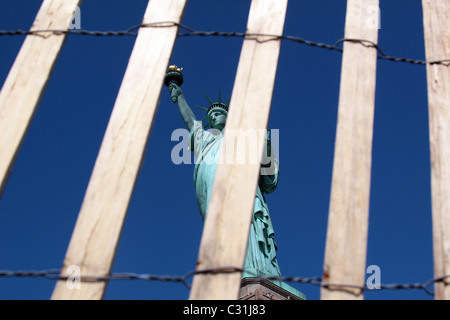 STATUE DE LA LIBERTÉ VUE À TRAVERS UN BOIS ET GRILLAGE, LIBERTY ISLAND, PORT DE NEW YORK, État de New York, UNITED STATES Banque D'Images