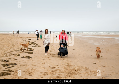 Une jeune famille avec leur bébé et le chien marcher sur la plage de Holkham, North Norfolk, UK Banque D'Images