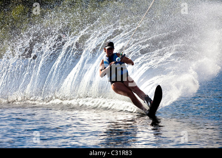 Une skieuse nautique déchire tour provoquant un énorme jet d'eau tandis que le ski sur le lac Cobbosseecontee près de Monmouth, Maine. Banque D'Images