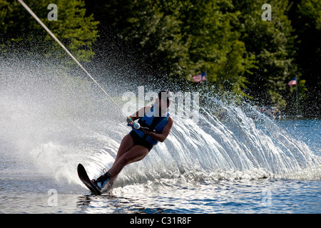 Une skieuse nautique déchire tour provoquant un énorme jet d'eau tandis que le ski sur le lac Cobbosseecontee près de Monmouth, Maine. Banque D'Images