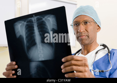 Mixed Race chirurgien looking at x-rays Banque D'Images