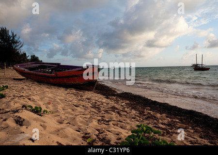 Low angle view of a red Dhow sur la plage à marée basse dans l'archipel de Bazaruto, le Mozambique. Banque D'Images