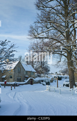 Cottage traditionnel au cours de temps de neige dans le village de Swinbrook, les Cotswolds Banque D'Images