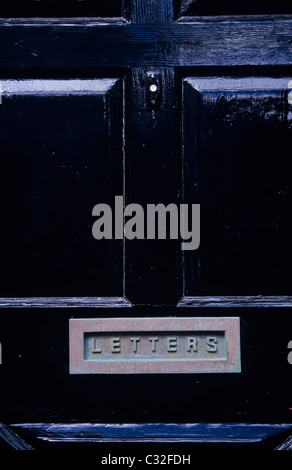 Détail de porte avant peint en noir avec bellpush et grandes lettres avec des lettres en relief sur le clapet métallique Banque D'Images