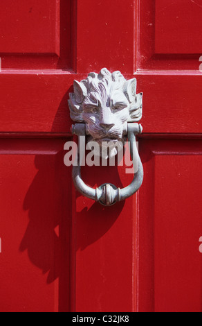 Détail de scarlet red porte avant avec tête de lion en plein soleil d'ombre coulée heurtoir Banque D'Images