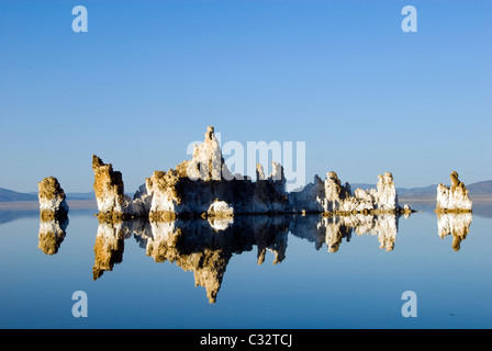 De grandes formations de tuf sont allumés et se reflètent dans la lumière de l'après-midi dans le lac Mono, CA. Banque D'Images