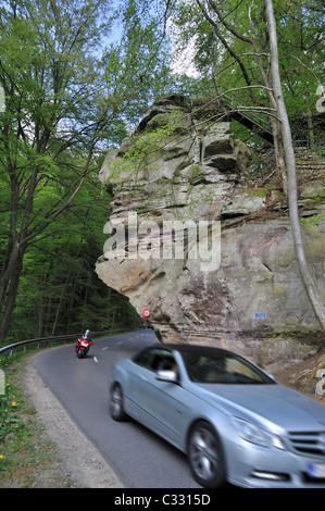 Voiture et biker conduite sous l formation de roche de grès dans Predigtstuhls Berdorf, Petite Suisse / Mullerthal, Luxembourg Banque D'Images