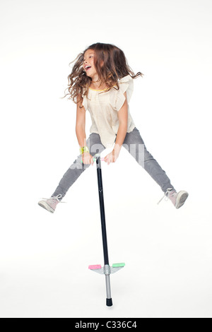 Une jeune fille sautant sur un Pogo Stick. Banque D'Images