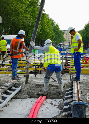 Paris, France, Tramway T3 Les travailleurs au site de construction, les hommes le coulage du béton pour voies de tram soutenir Banque D'Images