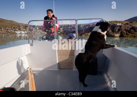 L'homme sur son bateau avec son fils et son chien, le sud du Groenland Banque D'Images