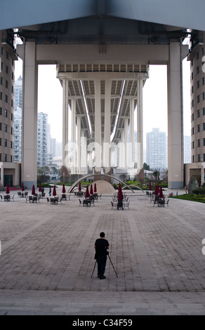 Un photographe se tient sous le pont Lupu à Shanghai, Chine, et est éclipsé par l'ampleur de celui-ci. Banque D'Images