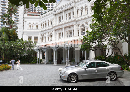 Les jeunes mariés en face du Raffles Hotel Singapore Banque D'Images