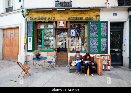 Deux femmes lisant devant la librairie Shakespeare and Company dans le quartier Latin, Paris, France Banque D'Images