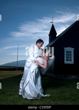 Mariée et le Marié danser devant Budir église avec Glacier Snaefellsjokull en arrière-plan, l'Islande Banque D'Images