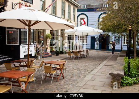 Des tables et des chaises à l'extérieur de restaurants dans la rue de l'église, une petite rue pavée à Windsor, Berkshire, England, UK Banque D'Images