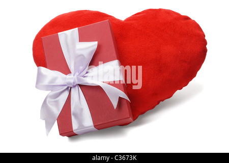 Boîte cadeau rouge avec noeud ruban sur coussin en forme de coeur d'amour Banque D'Images