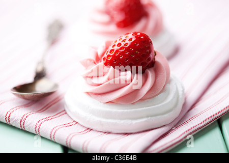 Les nids de meringue avec crème aux fraises et de fraises fraîches Banque D'Images
