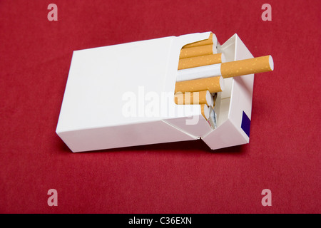 Paquet de cigarettes sur fond rouge Banque D'Images