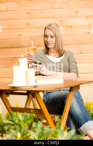 Jardin happy woman profiter de vin en verre assis sur terrasse Banque D'Images