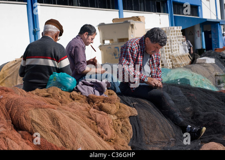 Les pêcheurs réparer leurs filets, port de pêche de Lagos, Portugal, l'Algarve Banque D'Images