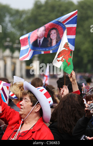 Brandissant des drapeaux par les gens pendant le mariage royal entre le Prince William et Kate Middleton à Buckingham Palace Banque D'Images