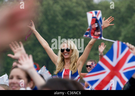 Fêteuse de mariage royale féminine avec robe union jack et drapeaux célèbre avec la foule à Hyde Park Londres, Royaume-Uni Banque D'Images