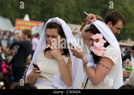 Mariage Royal carnavaliers habillés comme épouses avec des téléphones portables cigarette Hyde park Banque D'Images