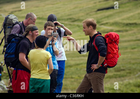 Le prince William partage une blague avec les membres de Centerpoint au Red Tarn durant son ascension de Helvellyn Banque D'Images