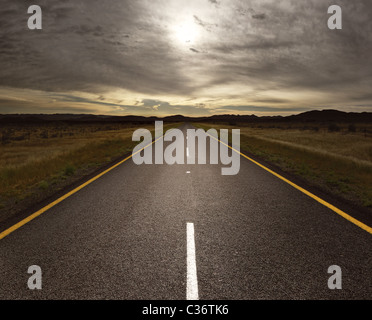 Tout droit route goudronnée menant à la lumière (image) tonique Banque D'Images