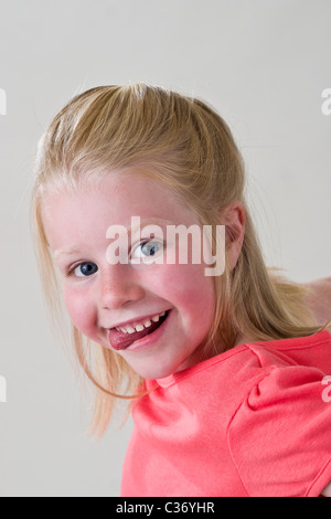 Silly little girl making faces hamming et il jusqu'à l'appareil photo à 6 ans, les enfants s'amusant monsieur © Myrleen Pearson Banque D'Images