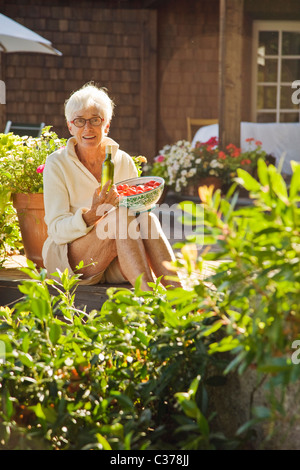 Senior woman holding tomatoes outdoors Banque D'Images