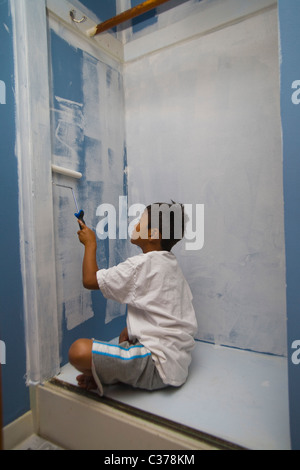 Boy painting wall en penderie Banque D'Images