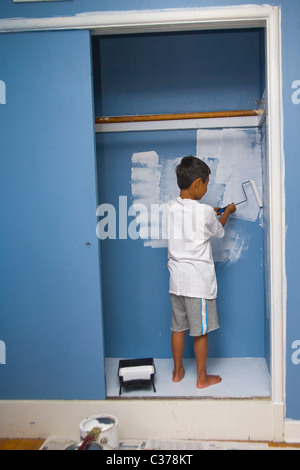 Boy painting wall en penderie Banque D'Images