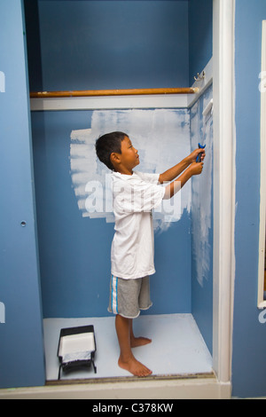 Boy painting wall en penderie Banque D'Images