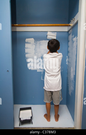 Boy painting wall en penderie Banque D'Images