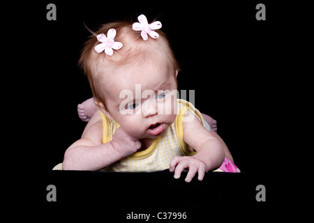 Une photographie d'un mignon bébé qui ressemble à elle pense bout quelque chose. Banque D'Images