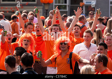 Kingsday (Queensday) l'anniversaire du roi à Amsterdam. Faire la fête sur un pont sur le Canal Prinsengracht. La bière Heineken dans la main Banque D'Images